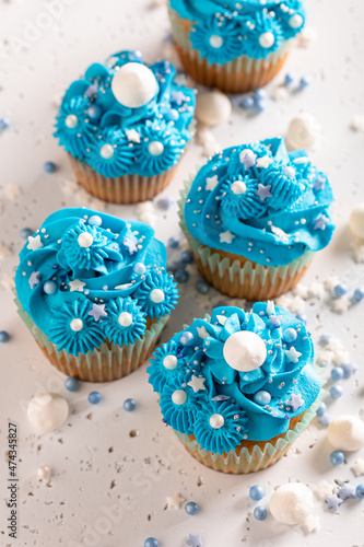 Unique cupcakes with blue whipped cream ready to eat.