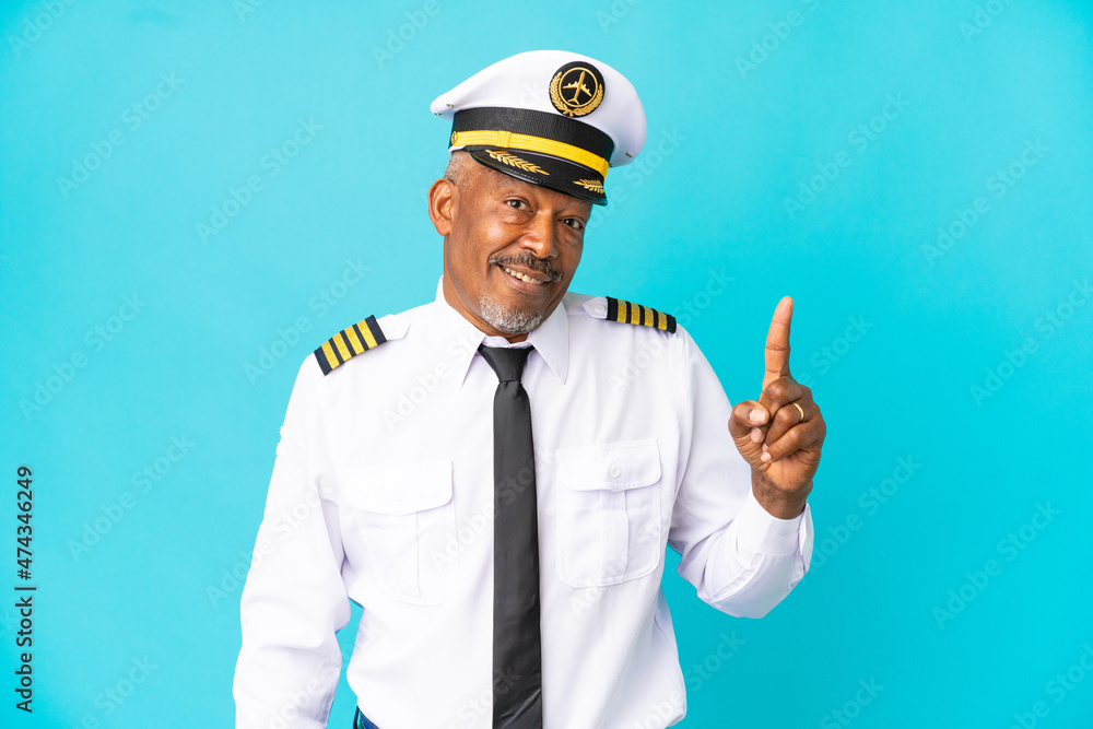Airplane pilot senior man isolated on blue background intending to realizes the solution while lifting a finger up Airplane pilot senior man isolated on blue background intending to realizes the solution while lifting a finger up