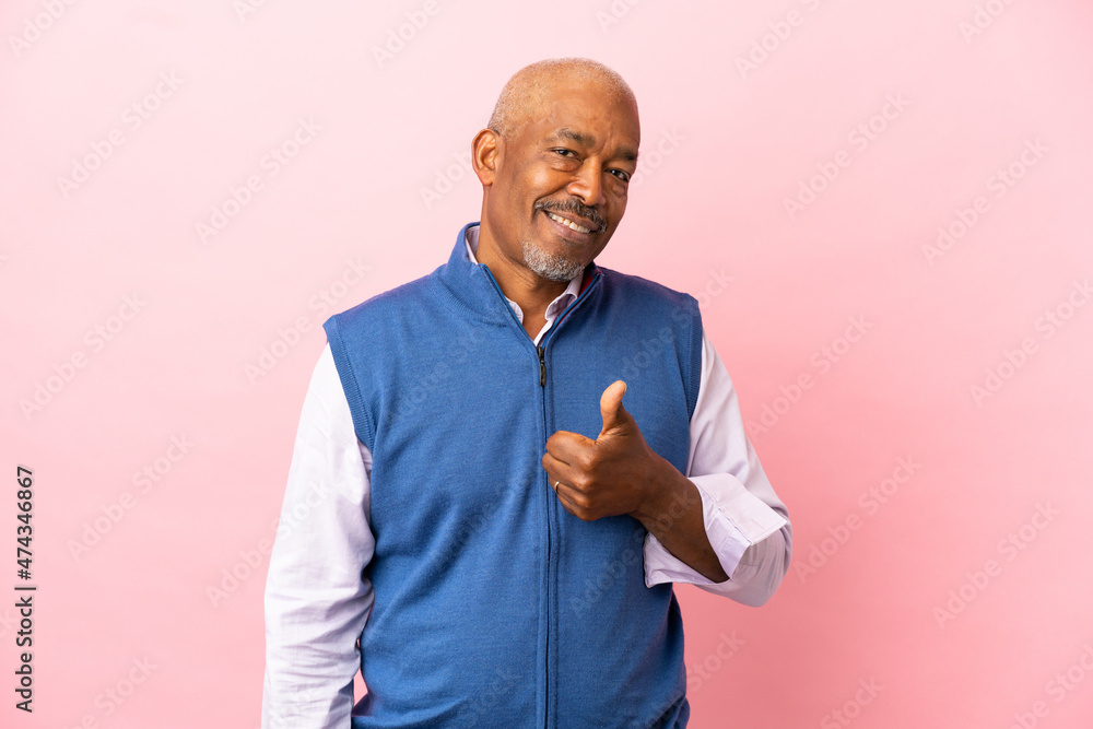Cuban senior isolated on pink background giving a thumbs up gesture Cuban senior isolated on pink background giving a thumbs up gesture
