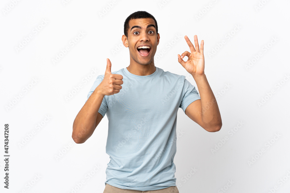 Fototapeta premium African American man over isolated white background showing ok sign and thumb up gesture