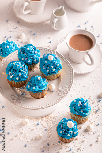 Homemade blue cupcakes with cream and sprinkles for fat thursday.