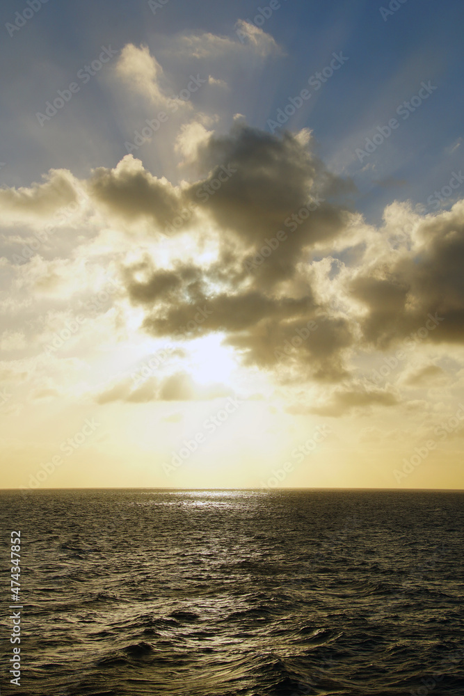 Morning on the open ocean. Atlantic. Bright sun and clouds. Vertical shot.