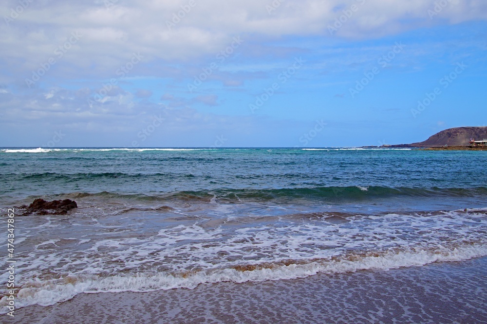 Fototapeta premium Beach in the Canary Islands. Surf waves and endless horizon. Sky and clouds.