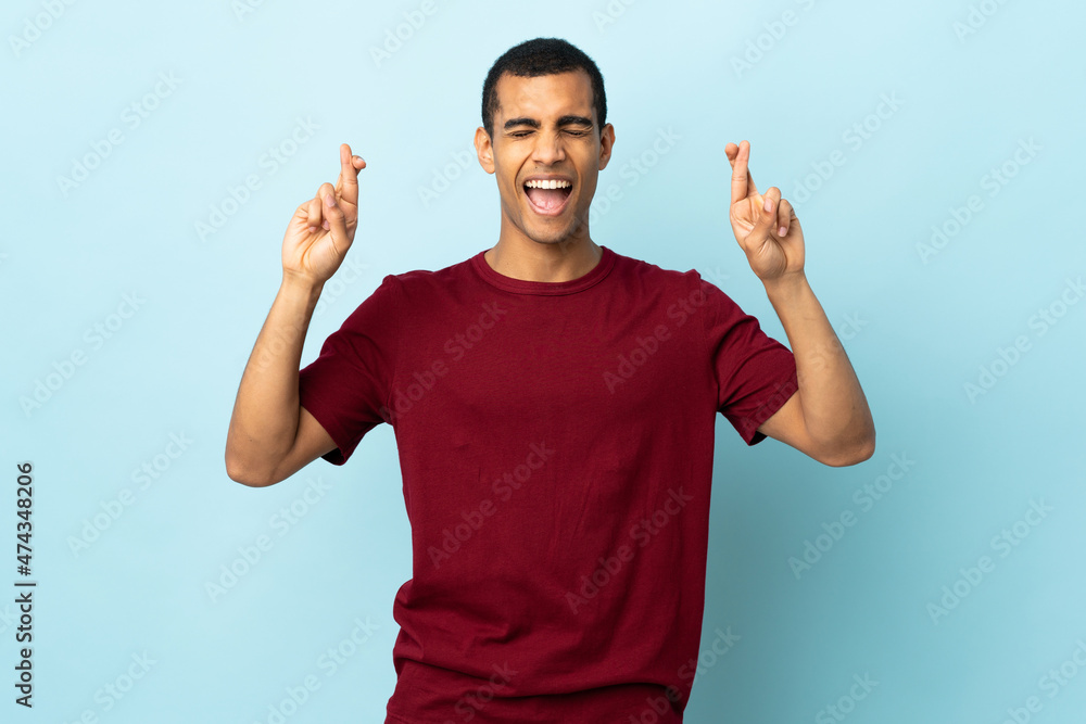 Fototapeta premium African American man over isolated background with fingers crossing