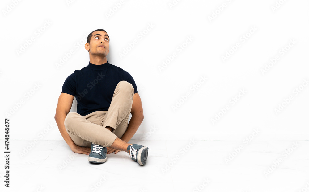 Fototapeta premium African American man sitting on the floor and looking up