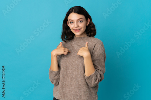 Teenager Ukrainian girl isolated on blue background with surprise facial expression