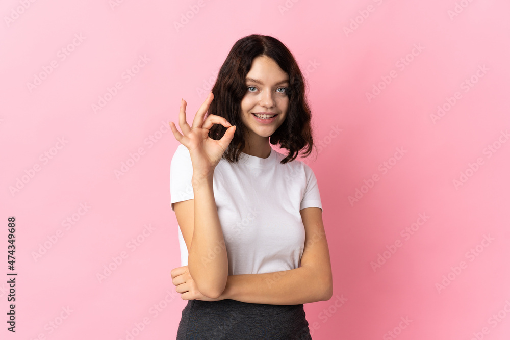 Teenager Ukrainian girl isolated on pink background showing ok sign with fingers Teenager Ukrainian girl isolated on pink background showing ok sign with fingers