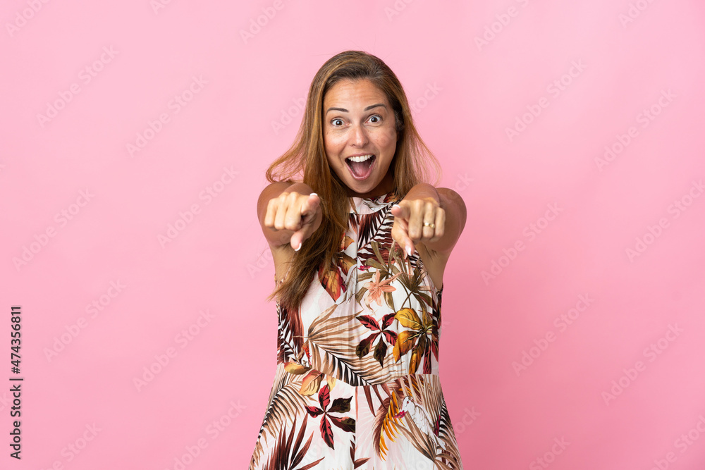 Middle age brazilian woman over isolated background surprised and pointing front Middle age brazilian woman over isolated background surprised and pointing front