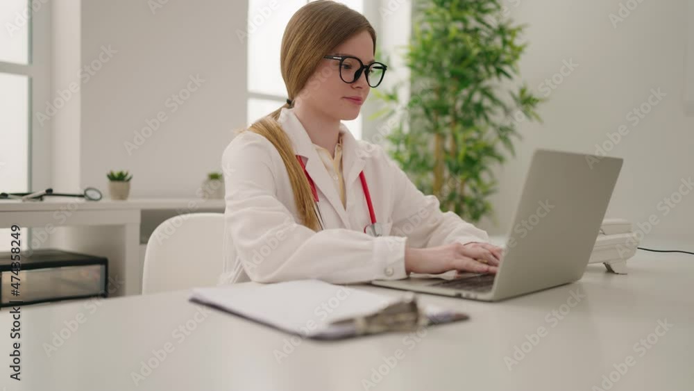 Young blonde woman wearing doctor uniform working at clinic Young blonde woman wearing doctor uniform working at clinic