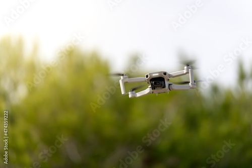 Drone flying near some trees with the background out of focus
