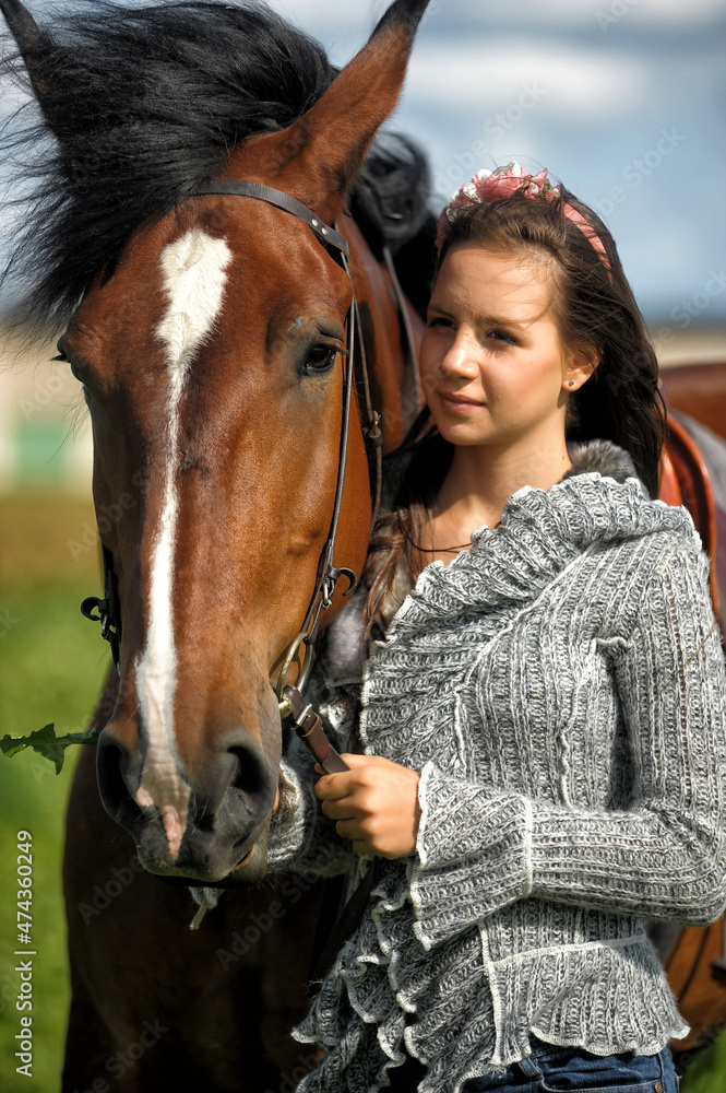 Obraz premium teenager girl with a horse in the field