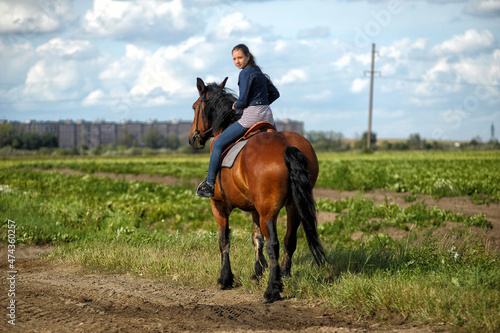 teenager girl with a horse in the field