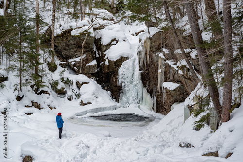 Hikers near frozen Kinsman Falls in Franconia Notch State Park during winter . New Hampshire mountains. USA. photo