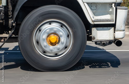 A spinning wheel of a truck running on the road. Detail of a rotating wheel of a truck rides on the highway.