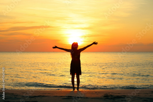 Silhouette of young woman enjoying victory and rise the hands with sunset sky , Freedom, travel and uccessful concept sconcept