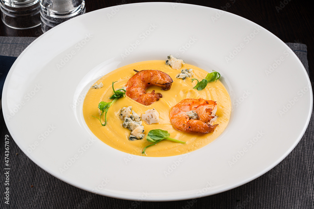 Autumn food pumpkin soup with shrimps. Served for dinner Autumn food pumpkin soup with shrimps. Served for dinner