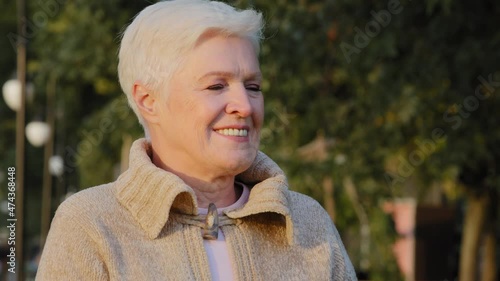 Closeup wrinkled face of 65s happy elderly woman outdoors looking aside having wide smile, dental implants and prostheses satisfied client portrait, insurance for older people, natural beauty concept photo