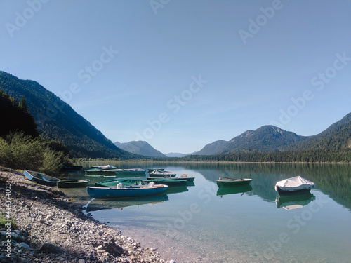 Sylvensteinsee Germany Alps, boards in the lake and mountains on background