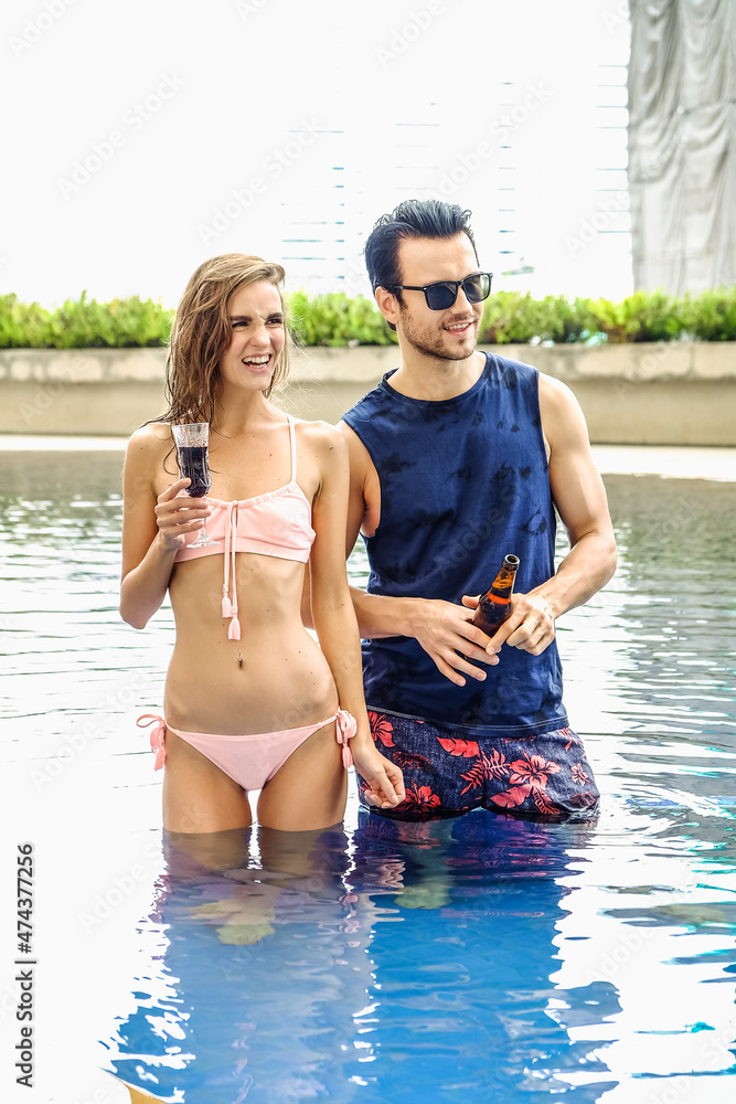 Portrait couple in love, sexy bikini poolside party enjoy having fun in swimming pool Portrait couple in love, sexy bikini poolside party enjoy having fun in swimming pool