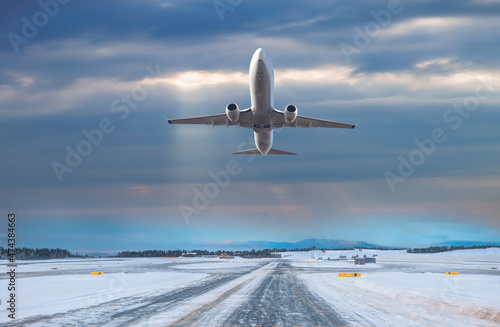 Commercical white airplane fly up over take-off runway the (ice) snow-covered airport- Norway © muratart