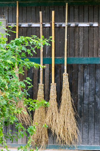 Slika na platnu some besom brooms on a dark wooden wall