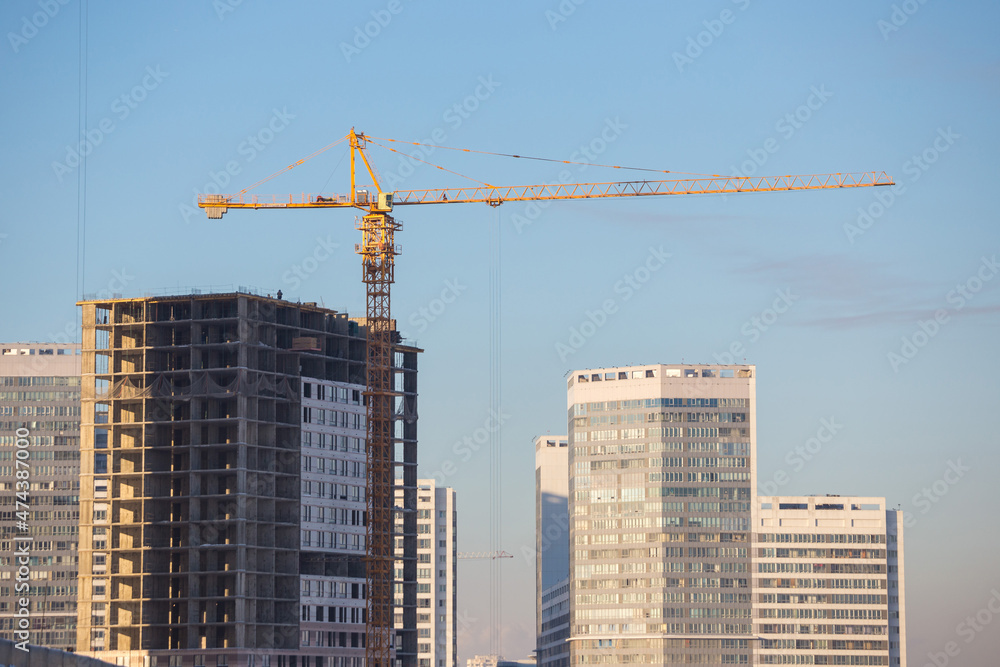 Construction of a multi-storey building. A high-rise crane on the construction of a multi-storey building. Construction of a multi-storey building. A high-rise crane on the construction of a multi-storey building.