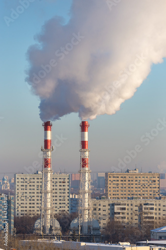 View of the city on a clear frosty day. Pipes of the city boiler house with thick steam.