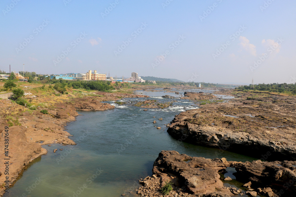 areal view of flowing water in river with big rock during summer in India