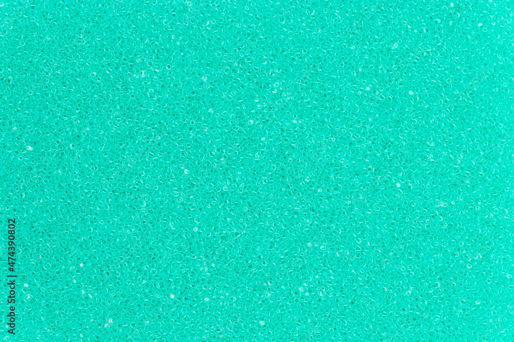 Turquoise color foam sponge porous texture background. Extreme close-up view of detail abstract synthetic material. Horizontal composition.