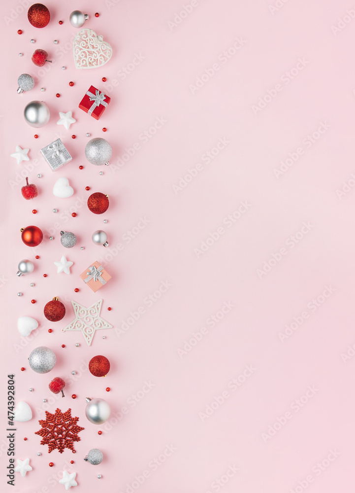 Beautiful pink greeting card with red and sliver Christmas ornaments and baubles border and copy space