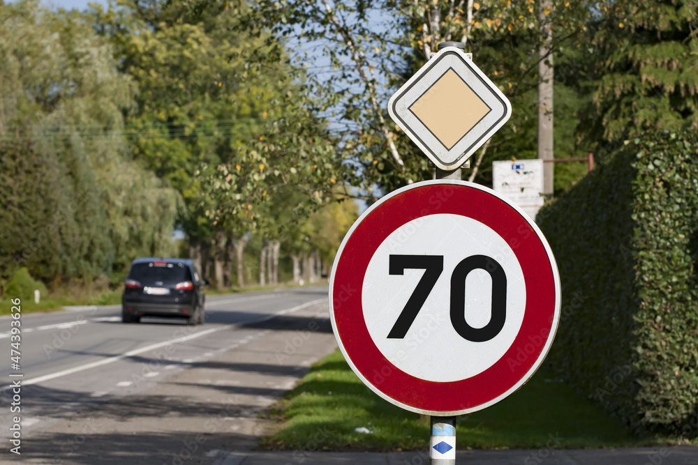 Panneau de limitation de vitesse 70 km/h sur route prioritaire. Stock Photo  | Adobe Stock