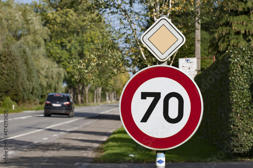 Panneau de limitation de vitesse 70 km/h sur route prioritaire.