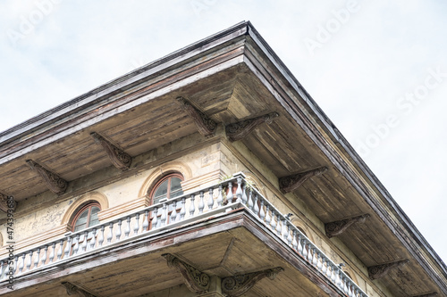 Wraparound balcony and upper corner of historic mansion showing architectural details of Italianate design photo