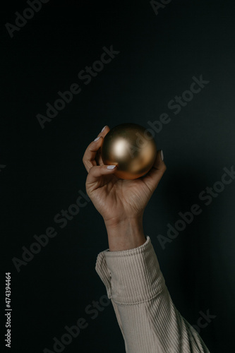 woman holding a golden matte christmas tree bauble. High quality photo