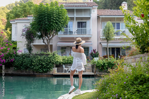 Woman walking on the riverfront in luxury residential neighborhood. photo