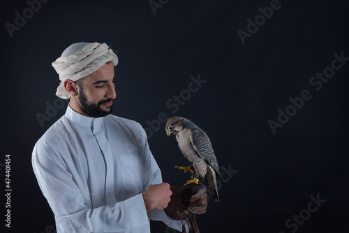 Young falconer holding a bird of prey.