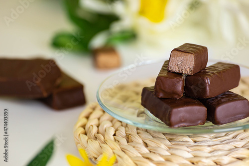 cioccolatini ripieni di cioccolato leggero su tavola di legno con fiore in fondo photo