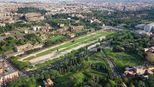 Aerial drone video of iconic Circus Maximus a green space and remains of a stone - marble arena used for chariot races built next to Palatine hill and world famous Colosseum, historic Rome, Italy photo