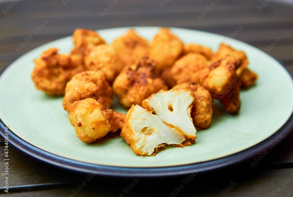 Vegan cauliflower buffalo wings on white wooden table.Tasty vegetarian food top view. crispy fried cauliflower bites