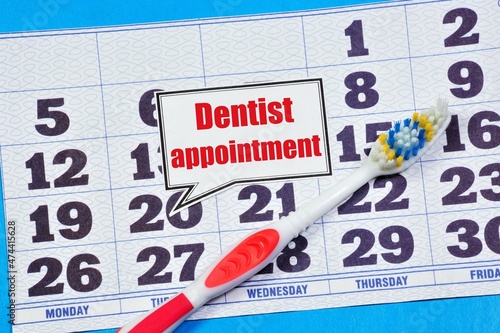 Dentist appointment. The inscription of planning on the background of a calendar and a toothbrush. Healthy oral hygiene.