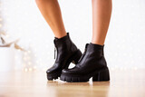 New collection of women's shoes fall-winter 2022. The girl bought new shoes. Legs in black boots.