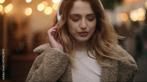 Wallpaper Mural Slow motion of smiling young blond listening to music in headphones at the city street. Closeup face of beautiful young girl with long hair. High quality 4k footage Torontodigital.ca