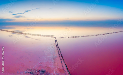 Lake with pink water on a background of dawn sky. Drone view. photo