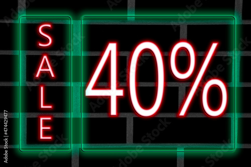 Pink neon inscription 40 percent discount in green neon frame on brick wall background