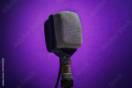 Vintage microphone, in a purple background. Retro professional equipment used on recording music.