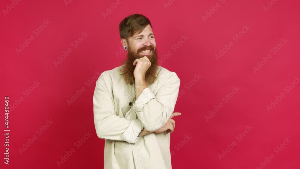 Redhead man with long beard standing and looking to the side over isolated background Redhead man with long beard standing and looking to the side over isolated background