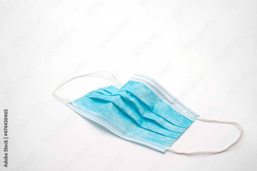 Disposed face mask over white background covid 19 pandemic waste Disposed face mask over white background covid 19 pandemic waste