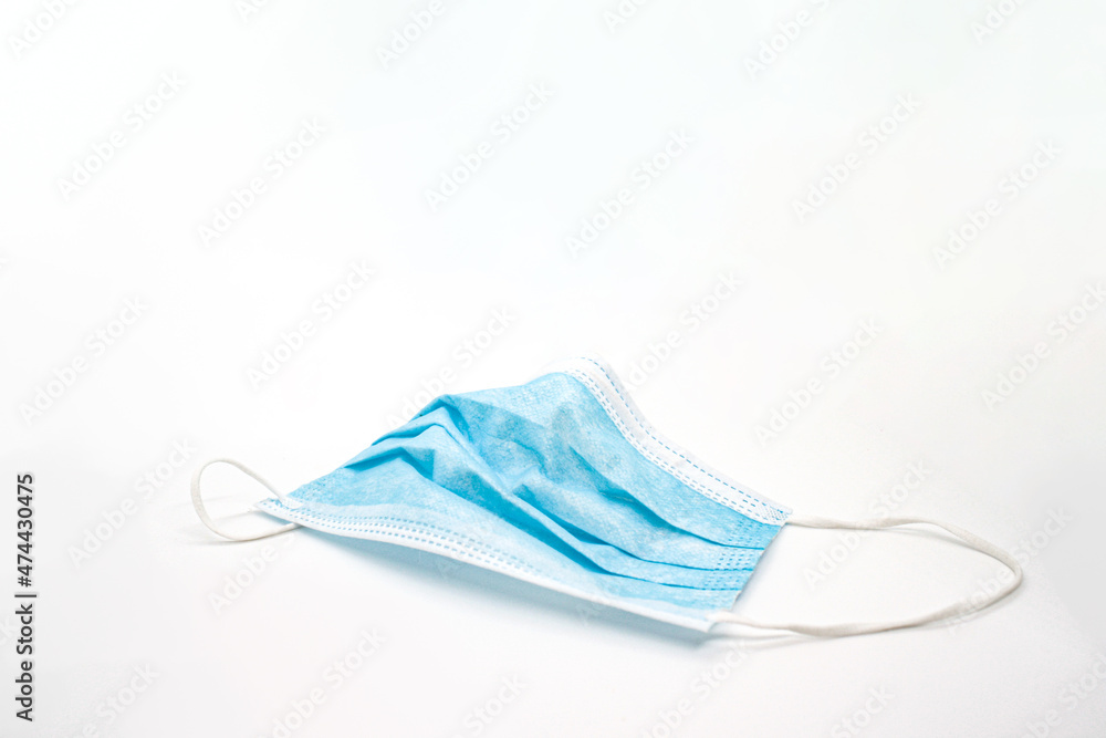 Disposed face mask over white background covid 19 pandemic waste Disposed face mask over white background covid 19 pandemic waste