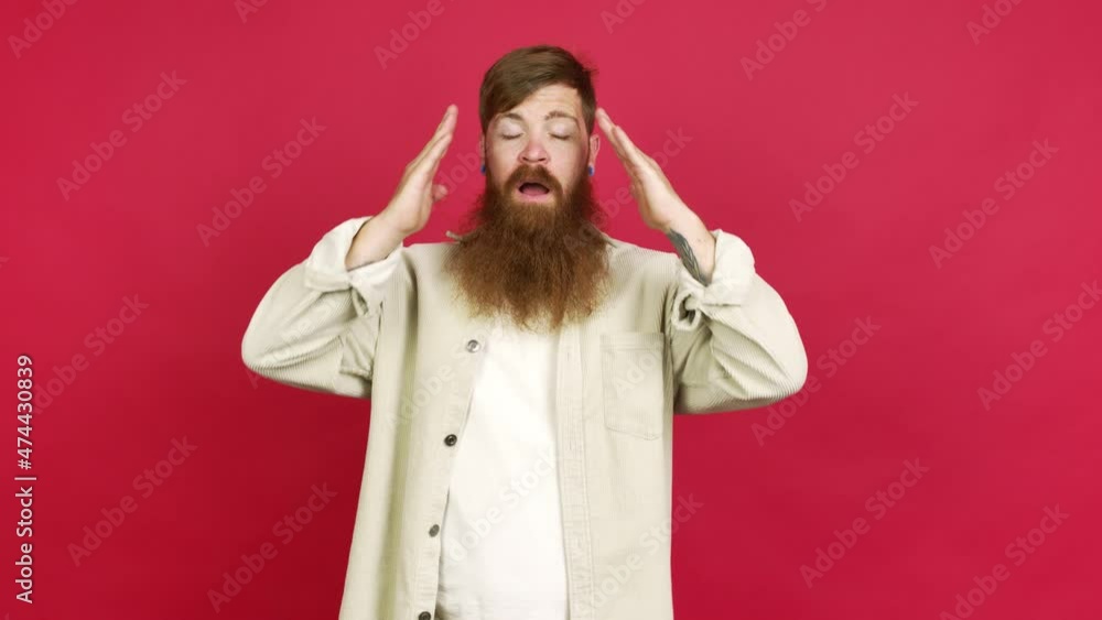 Redhead man with long beard unhappy and frustrated with something over isolated background Redhead man with long beard unhappy and frustrated with something over isolated background