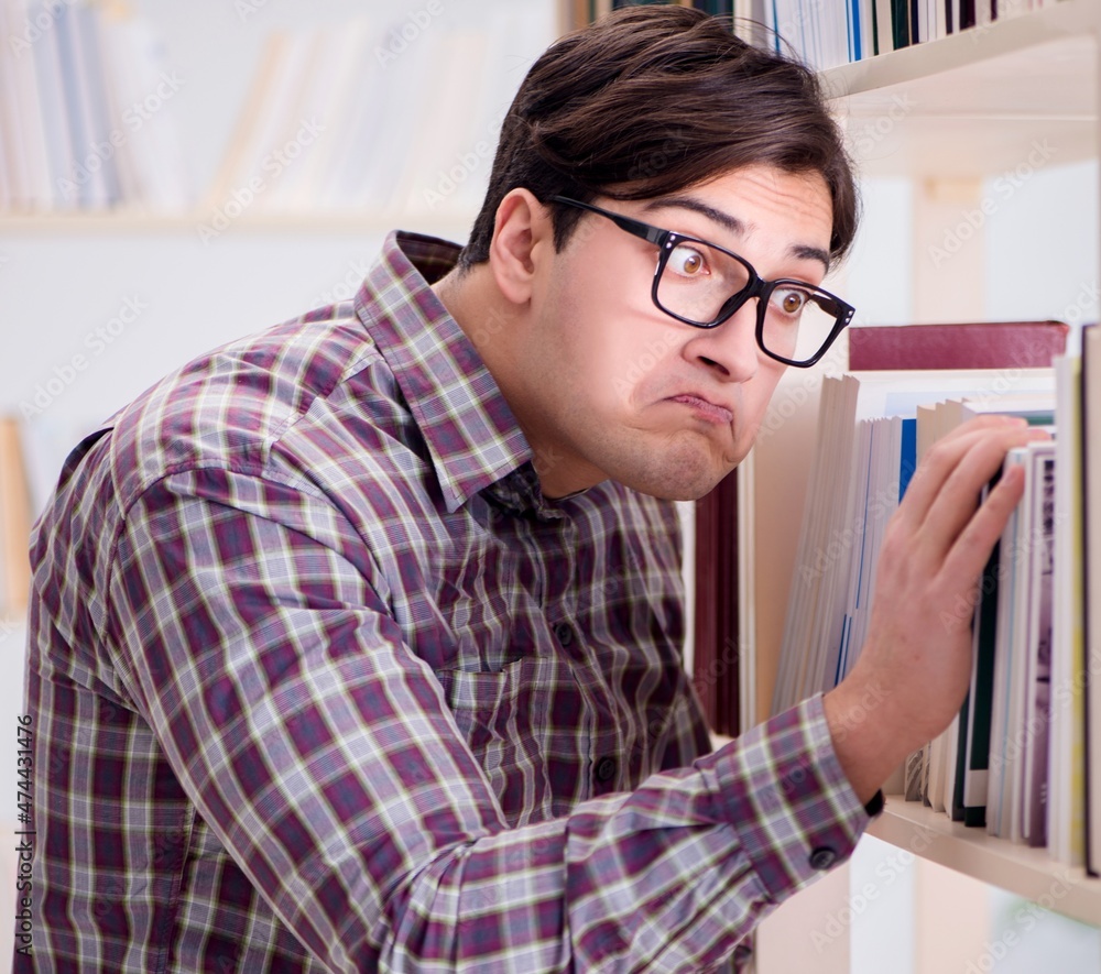 Young student looking for books in college library Young student looking for books in college library